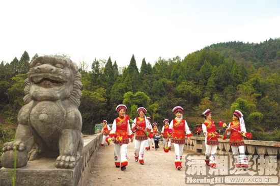 11月11日，桑植县芙蓉桥白族乡，身穿白族传统服饰的姑娘们走过芙蓉桥。 